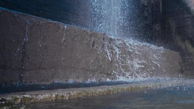 Low-angle shot of water splashing violently at the base of a concrete weir dam. 
Low-angle shot of a digital cup anemometer spinning against a clear blue sky. 
