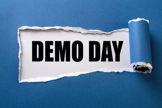 Demo day phrase written on white paper under torn dark blue background