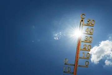 Blue sky on a hot summer day with sun and a thermometer. Extremely hot weather forecast. © Igor