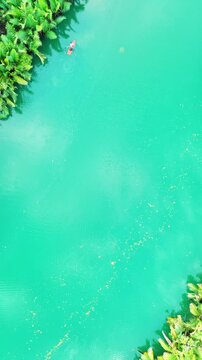Aerial top view of kayak passing on the stunning mirror-like Loboc river in Bohol Philippines