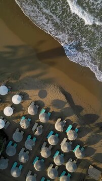 Top drone view of sun umbrellas on the sandy beach, tropical seascape, travel and vacation. 