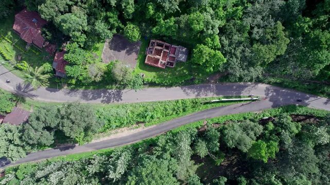 Aerial view of winding highways through lush Western Ghats forests during Karnataka's vibrant day