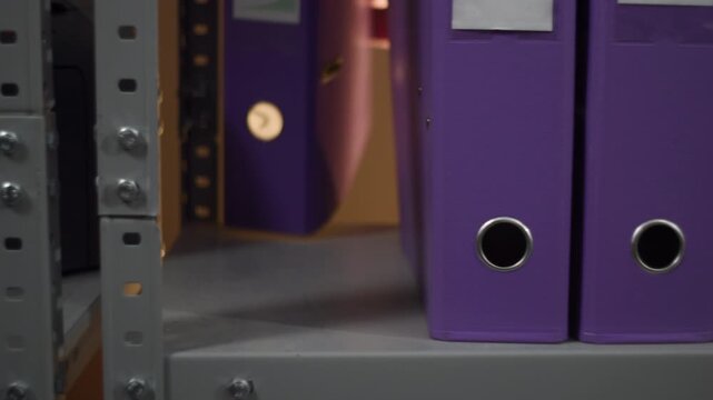 Purple ring binders arranged on an office shelf