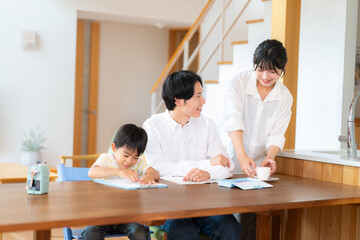 Fototapeta premium 勉強する小学一年生の男の子と教える両親