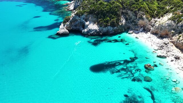 4K drone footage of Goloritz&egrave; Beach on the Baunei coast, Gulf of Orosei, Sardinia. Crystal-clear turquoise waters, white limestone cliffs, and one of Italy&rsquo;s most iconic seascapes