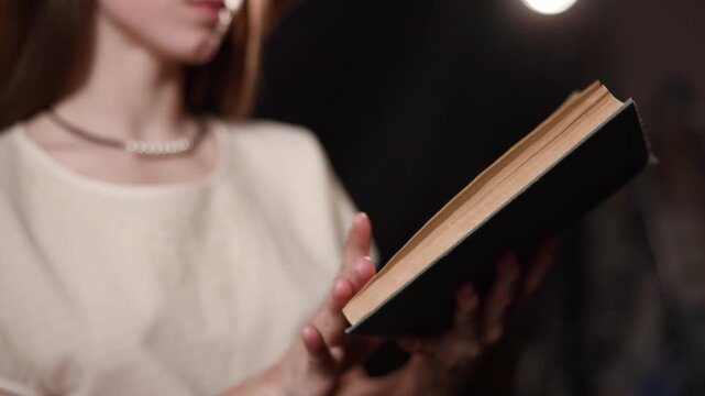 Young Woman Reading an Open Book Indoors