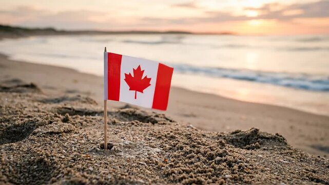 Canadian flag on sandy beach at sunset.