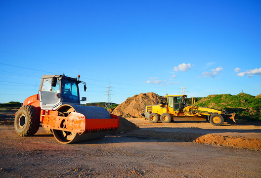 Soil Compactor on compact the road surface. Motor Grader on road construction.  Heavy machinery for grading and road compaction equipment at construction site. Greyder and road roller