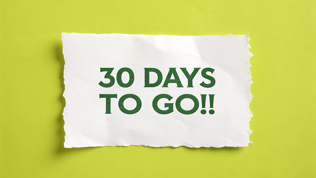 A piece of torn white paper with the text 30 days to go printed in dark green ink placed on a bright lime green background surface