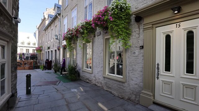 View of historic stone buildings with flower boxes along a narrow street in Old Quebec City, Quebec, Canada.