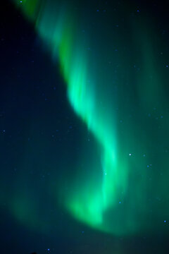 Green aurora lights glowing across a dark starry night sky