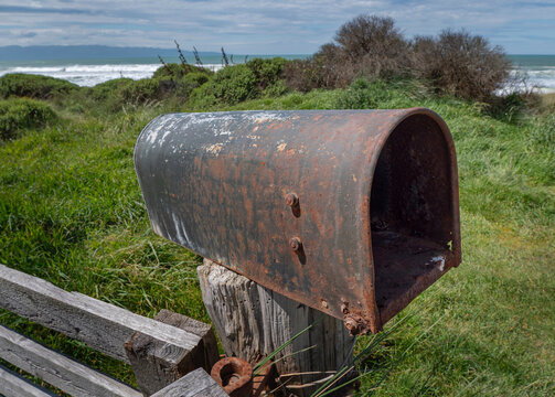 Rusty mailbox near the coast of Orepuki coast New Zealand. Westcoast Tasman Sea