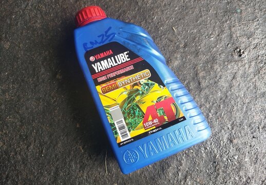 KUALA TERENGGANU MALAYSIA- JUNE 24. 2026. A 1-liter blue plastic bottle of Yamaha Yamalube High Performance Semi Synthetic 4T 10W-40 motorcycle engine oil placed on a dark textured workshop floor.