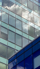 Obraz premium Reflection of clouds in glass building in a city environment