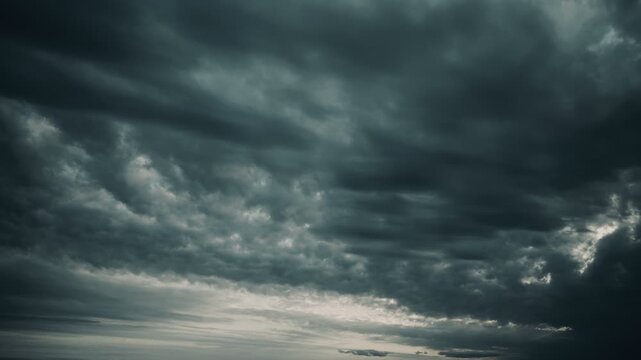 Gloomy thunderclouds are floating across the sky, thickening. A celestial timelapse of a cloudy sky.