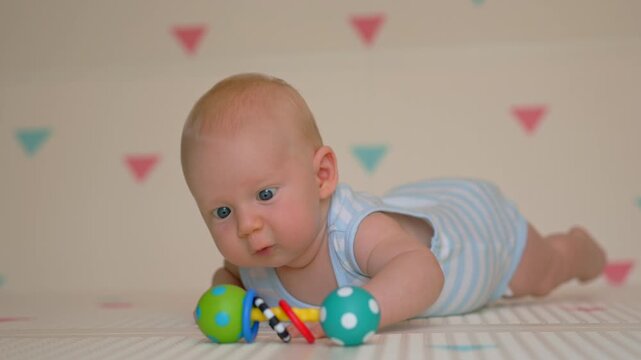 Baby boy moving arms and legs while learning to crawl. Slow motion.