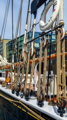 Sailing vessel with ropes and pulleys in a harbor on a sunny day © Creative house