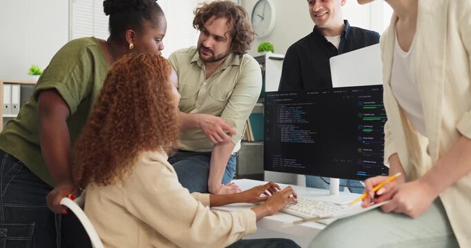 Programmers developers team meeting discussion on coding. Colleagues work at a computer in a modern office, reviewing software and planning for collaboration. Clear concept of digital teamwork.