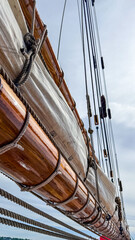 Close-up view of wooden mast and rigging on a sailing vessel near the coast © Creative house