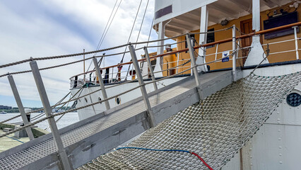 Fototapeta premium Docked ship with a ramp for boarding at a harbor during daytime