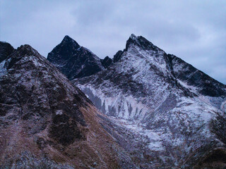 Obraz premium Snow covered mountain peaks under a cloudy sky