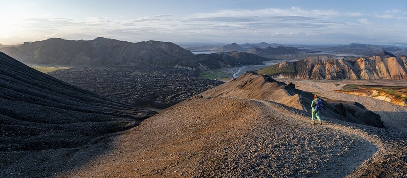Hiker on the Laugavegur trekking trail, Laugavegur trekking trail, Dramatic volcanic landscape, Colourful erosion landscape with mountains, Lava field, Landmannalaugar, Fjallabak nature reserve, Su&eth;urland, Iceland