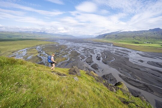 Hiker, Young woman on a hill, view over alluvial land, meandering river, D&iacute;monarhellir, Su&eth;urland, Iceland