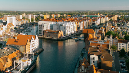 Gdańsk, Polska - Widok z góry na rzekę Motławę, historyczną Żuraw, Wyspę Spichrzów i Stare Miasto o zachodzie słońca. © wojciechkic.com