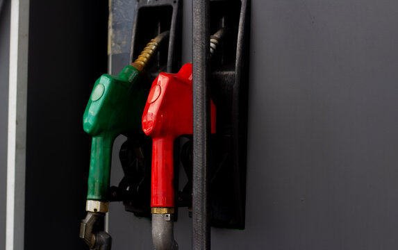 Horizontal street city photo close up. Old black gas station with red and green petrol gun, fuel dispenser, petroleum dispensing nozzle. Concept of sanction, transport, rising oil prices, auto service
