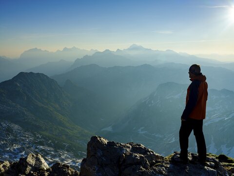 Mountaineers at the summit of Krn 2. 244m, Mount Triglav in the background, Triglav National Park, Julian Alps, Slovenia