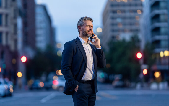 Business communication of businessman. Business man talking on phone outdoor. Businessman negotiation online. Man phone conversation in evening city. Mature Hispanic business man with phone