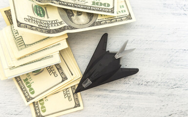 Fototapeta premium military miniature toy airplane on dollars background
