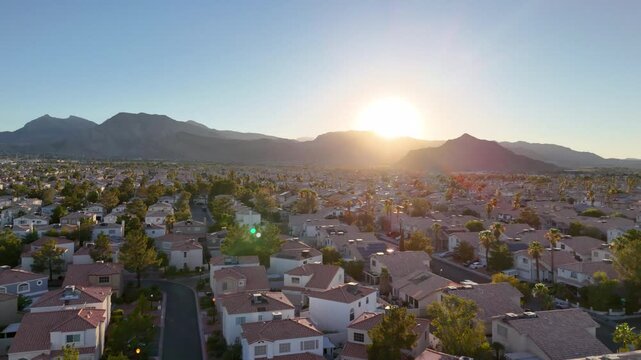 Aerial drone tracking shot over a Las Vegas suburban neighborhood at golden hour sunset