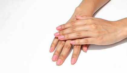 Fototapeta premium The Minimalist Manicure: Serene woman with minimalist pink manicure showcases gentle manicured hands on clean white background, radiating sense of calm beauty and grace