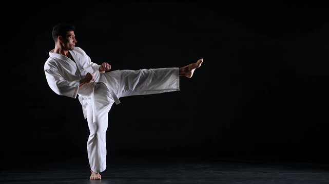 Karate martial arts, man and athlete in studio with kick, fitness training and professional fighter. Male, sport and workout in uniform with self defense, combat skills and healthy lifestyle exercise