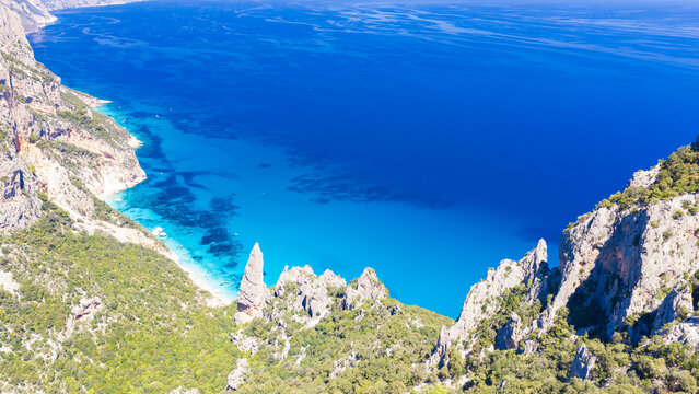 Aerial drone view of Cala Goloritz&egrave; on the Baunei coast, Gulf of Orosei, Sardinia. Iconic limestone pinnacle, turquoise waters, white cliffs, and pristine Mediterranean scenery.
