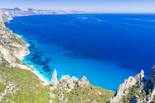 Aerial drone view of Cala Goloritz&egrave; on the Baunei coast, Gulf of Orosei, Sardinia. Iconic limestone pinnacle, turquoise waters, white cliffs, and pristine Mediterranean scenery.

