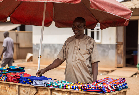 African Merchant Selling Colorful Fabrics and Crafts in Accra Market