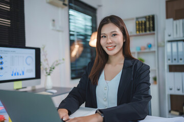 Fototapeta premium Asian businesswoman smiling and working in office