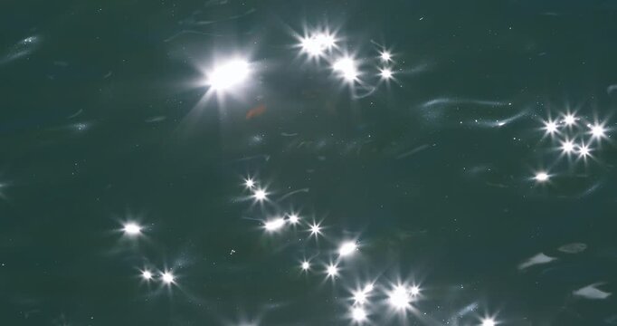 Abstract summer water surface with shimmering sun rays glare and sunlight sparkles, beautiful tropical travel background.