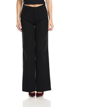 Studio shot of woman&rsquo;s lower body wearing black fashion pants and burgundy high heels standing on white background