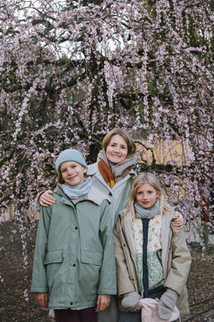 Mother with two daughters and a plum tree in bloom