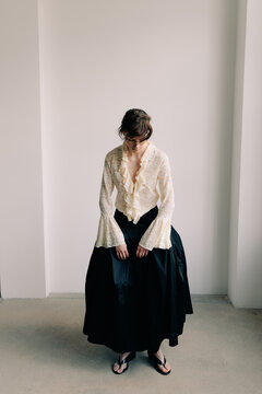 Minimal editorial portrait with lace blouse and voluminous skirt