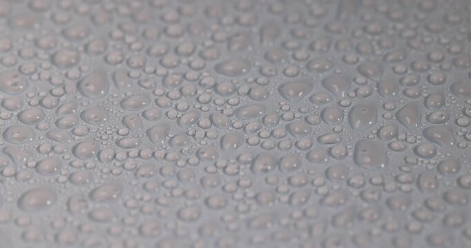 Condensation covers the plane, fine condensation and water droplets on a matte blue background with soft highlights in a macro with realistic texture and authentic appearance of the object.