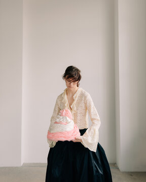 Minimal fashion scene with sculptural pastel textile object