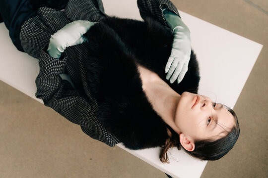 Elegant reclining fashion portrait with fur collar and satin gloves
