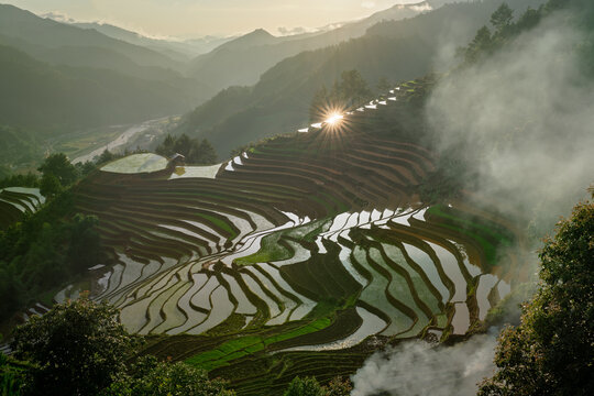 Sunstar over terraced valley