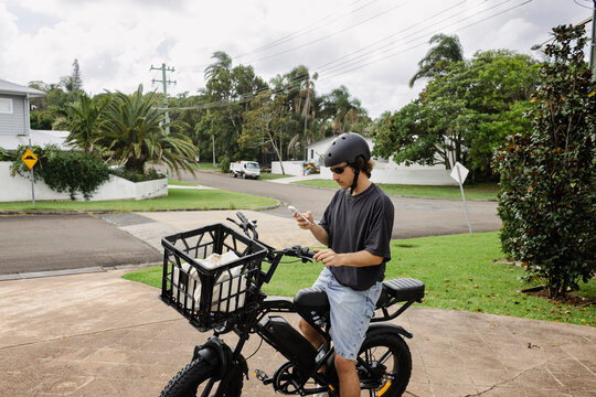 Checking phone before electric bike ride in Australia