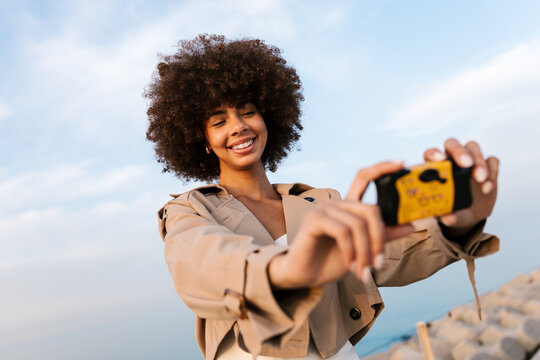 Woman capturing smiling selfie with action camera