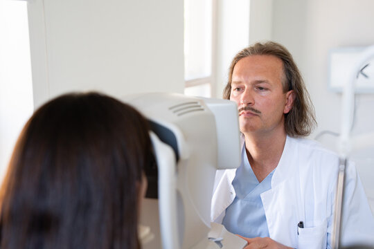 Doctor Checks Eyes of Patient in Clinic 